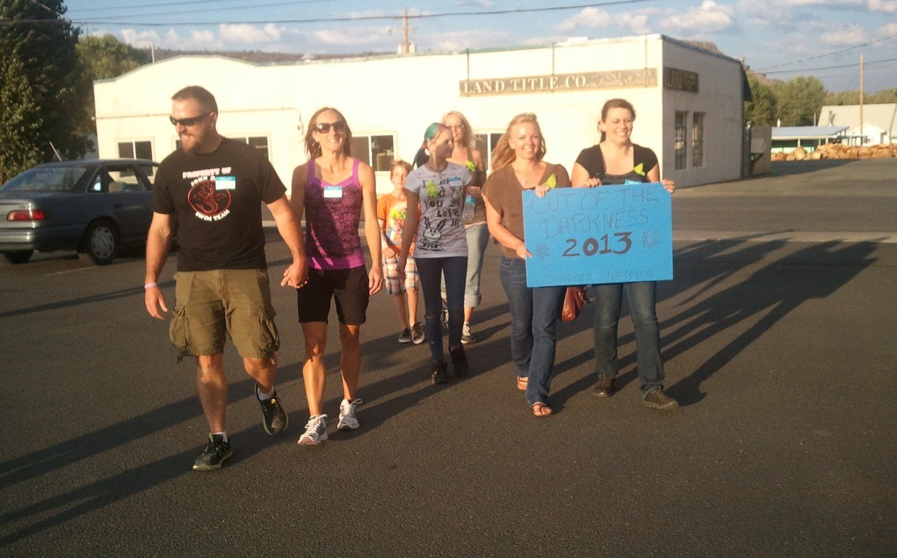 Marchers carrying a hand-lettered sign at the first Out of the Darkness walk in Grant County, Oregon